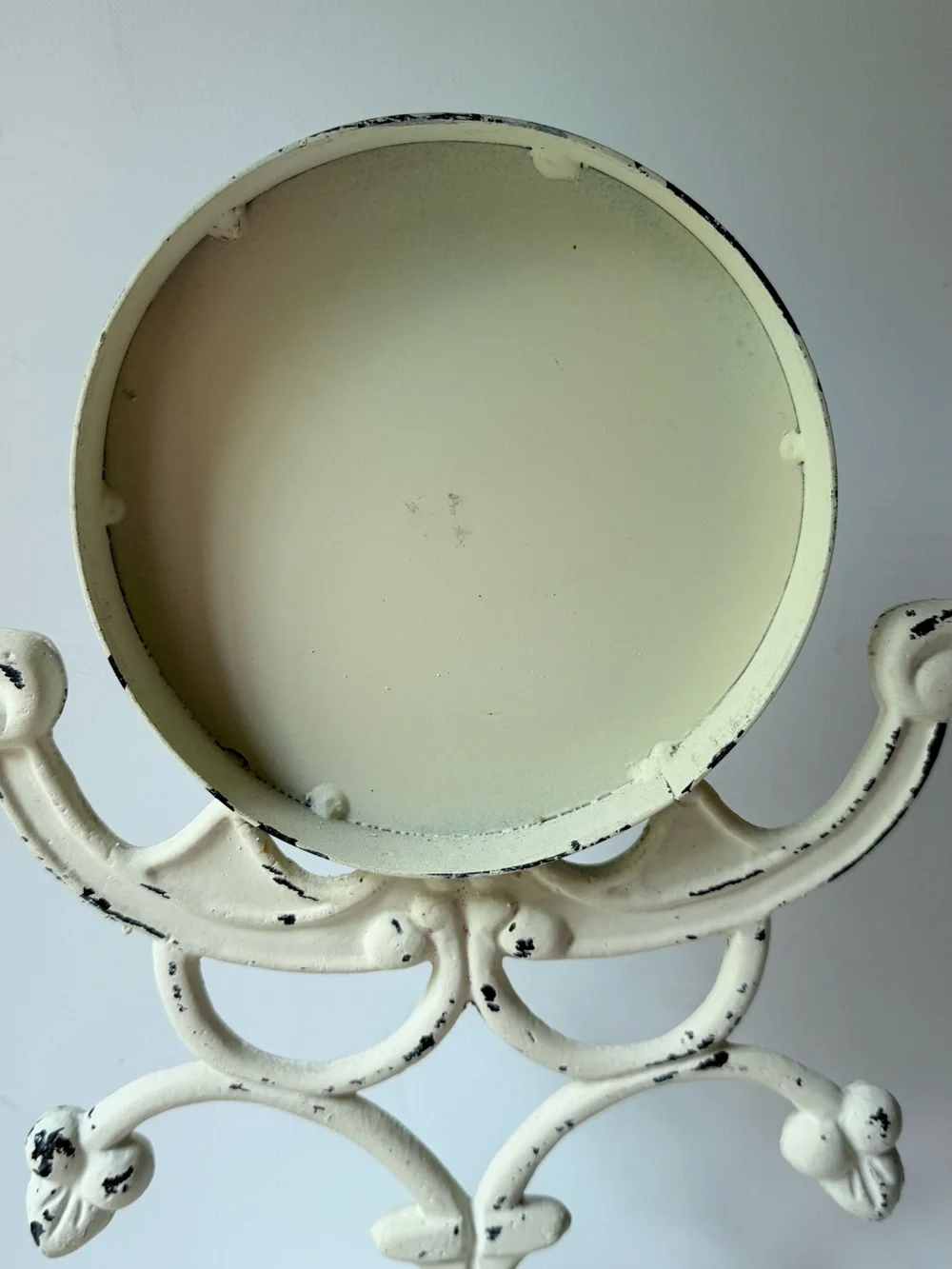 This vintage-style table clock features a distressed cream iron stand
